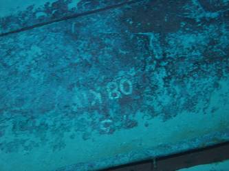 Large section of hull in debris field with "08KO" painted on plating